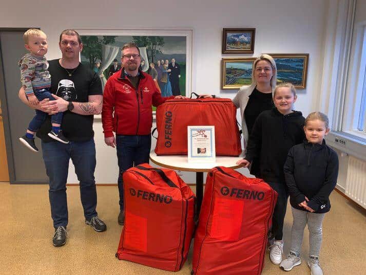 Fjölskylda og starfsmaður með rauðar Ferno töskur